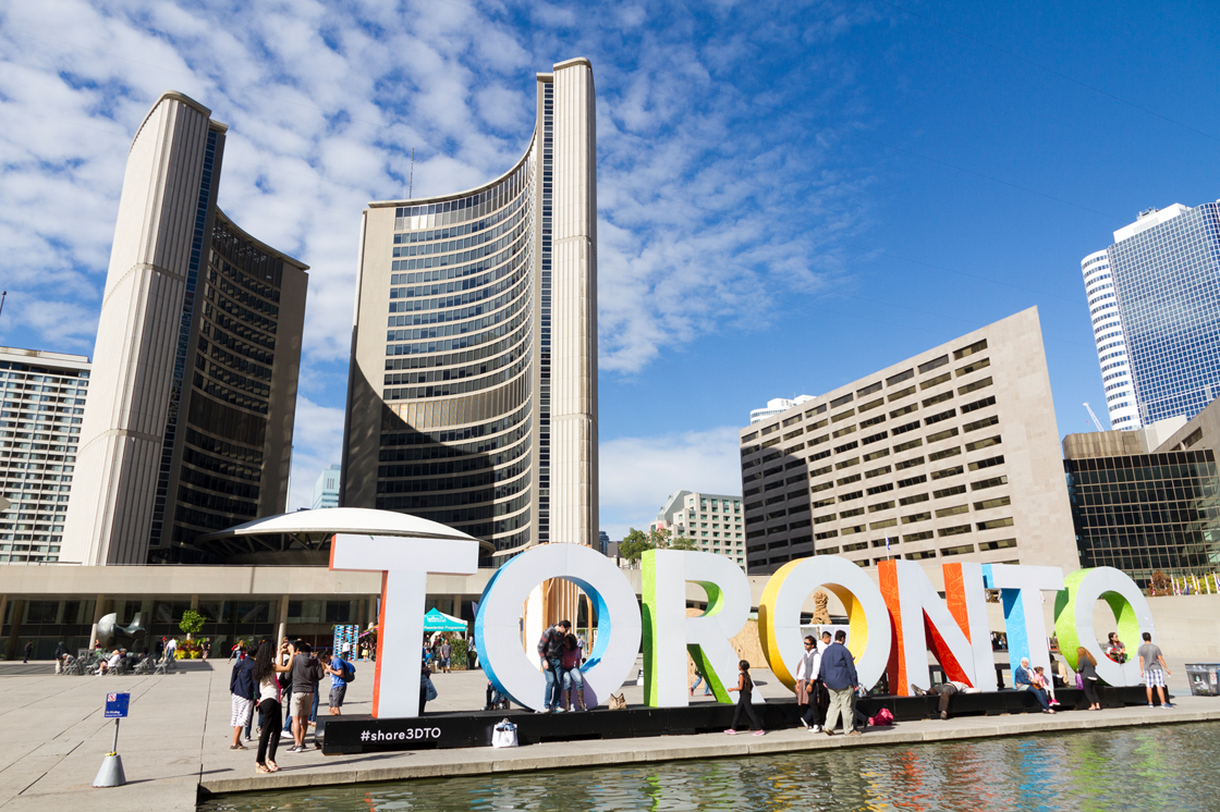 Nathan Phillips Square Toronto sign in front of Toronto City Hall.