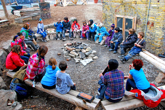 Kids circle around the campfire at Evergreen Brick Works.